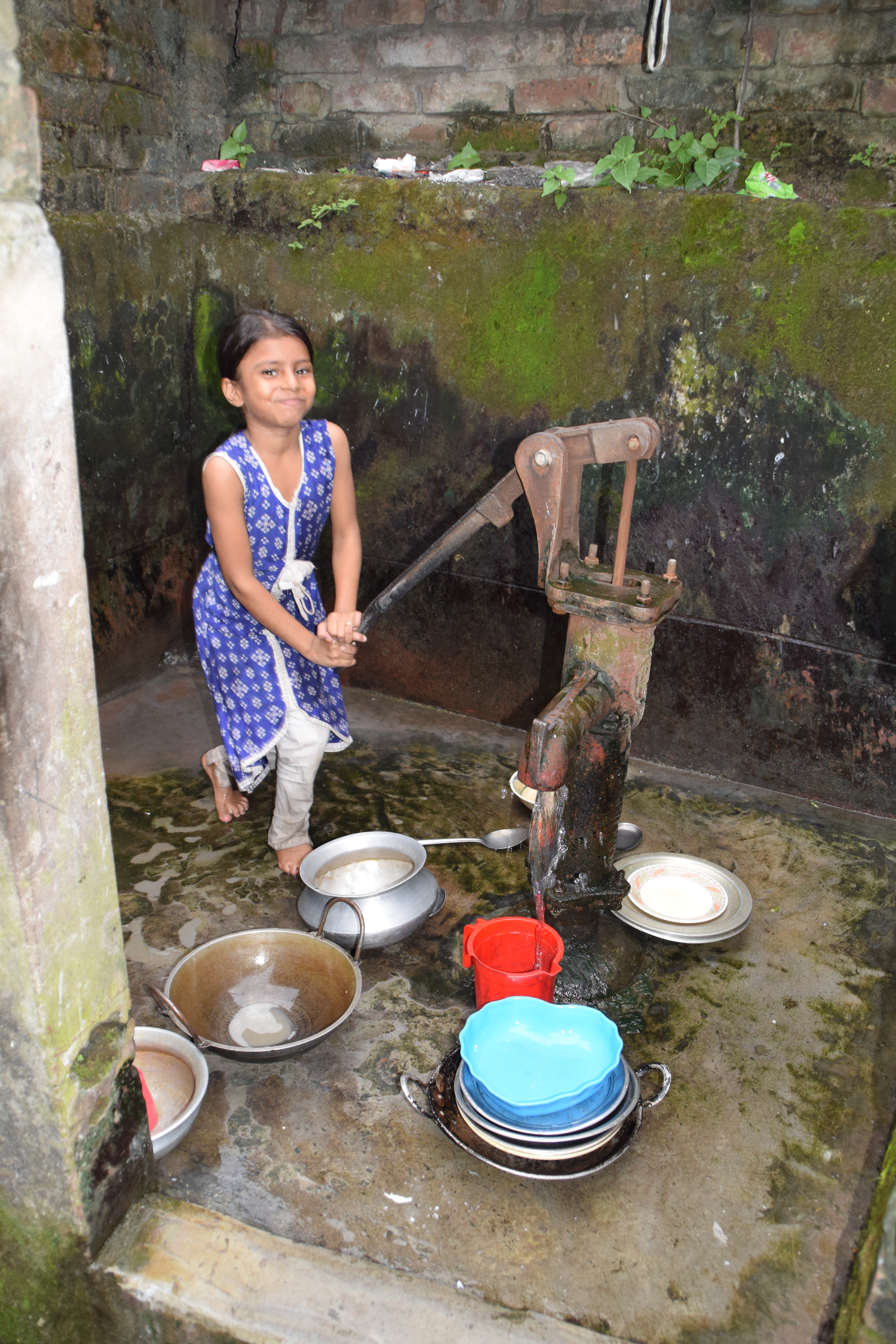 Niña sacando agua de un pozo en Chattogram, Bangladesh. Foto: Manos Unidas/Patricia Garrido