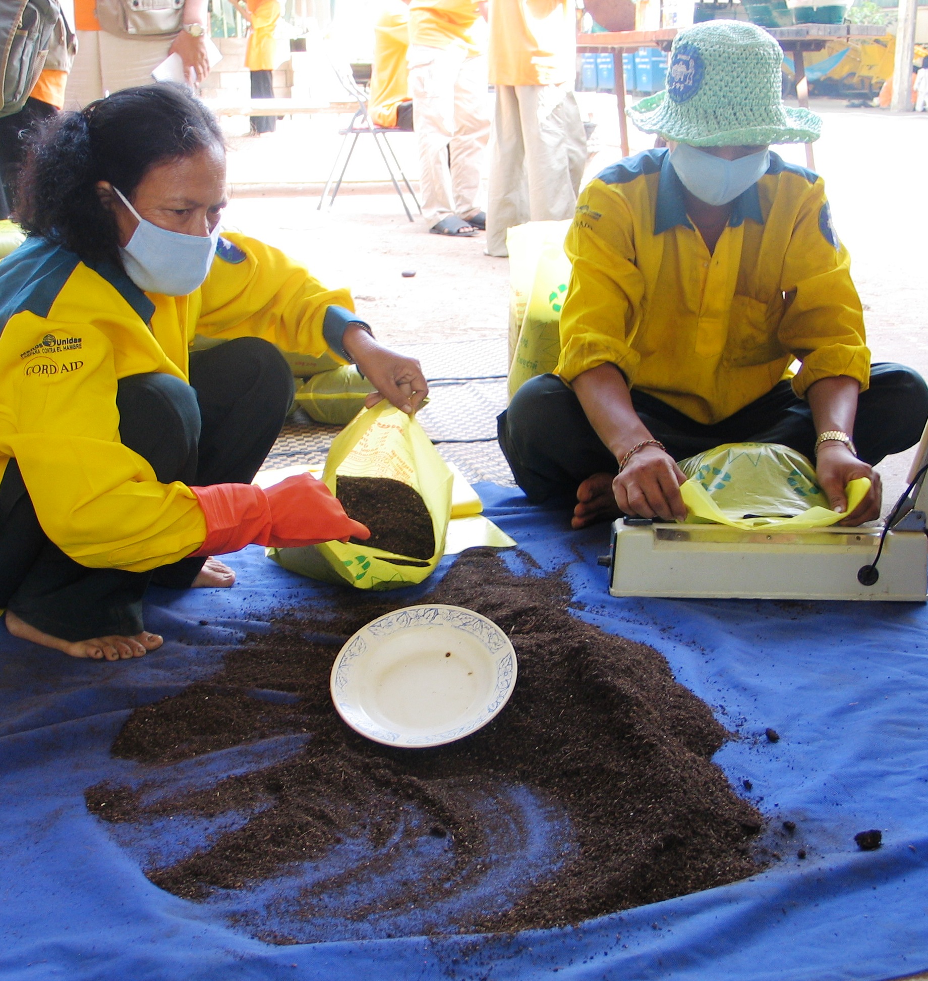 Personas envasando abono orgánico en Phnom Penh, Camboya
