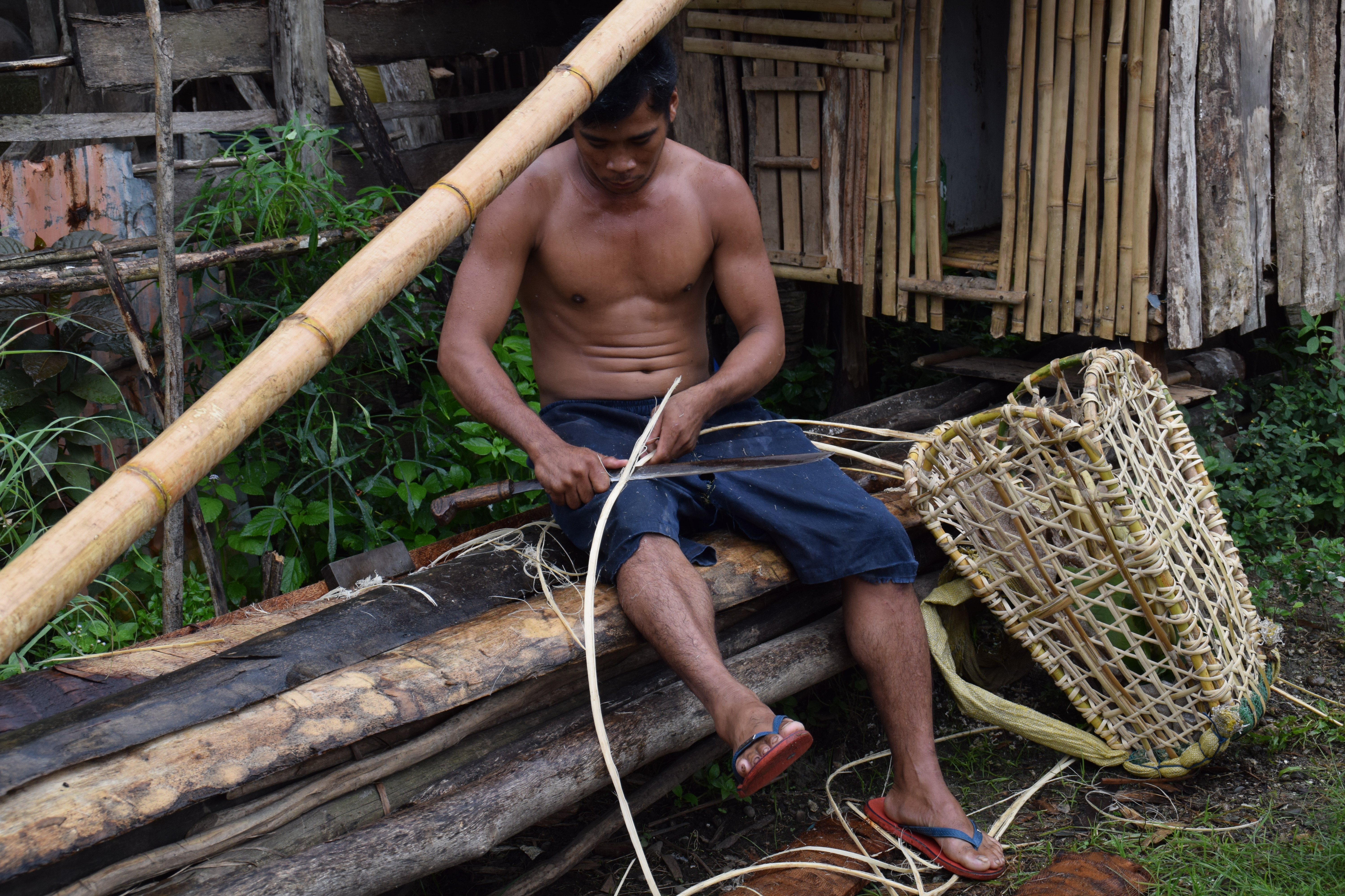 Un pescador de Filipinas elaborando una cesta de pesca.
