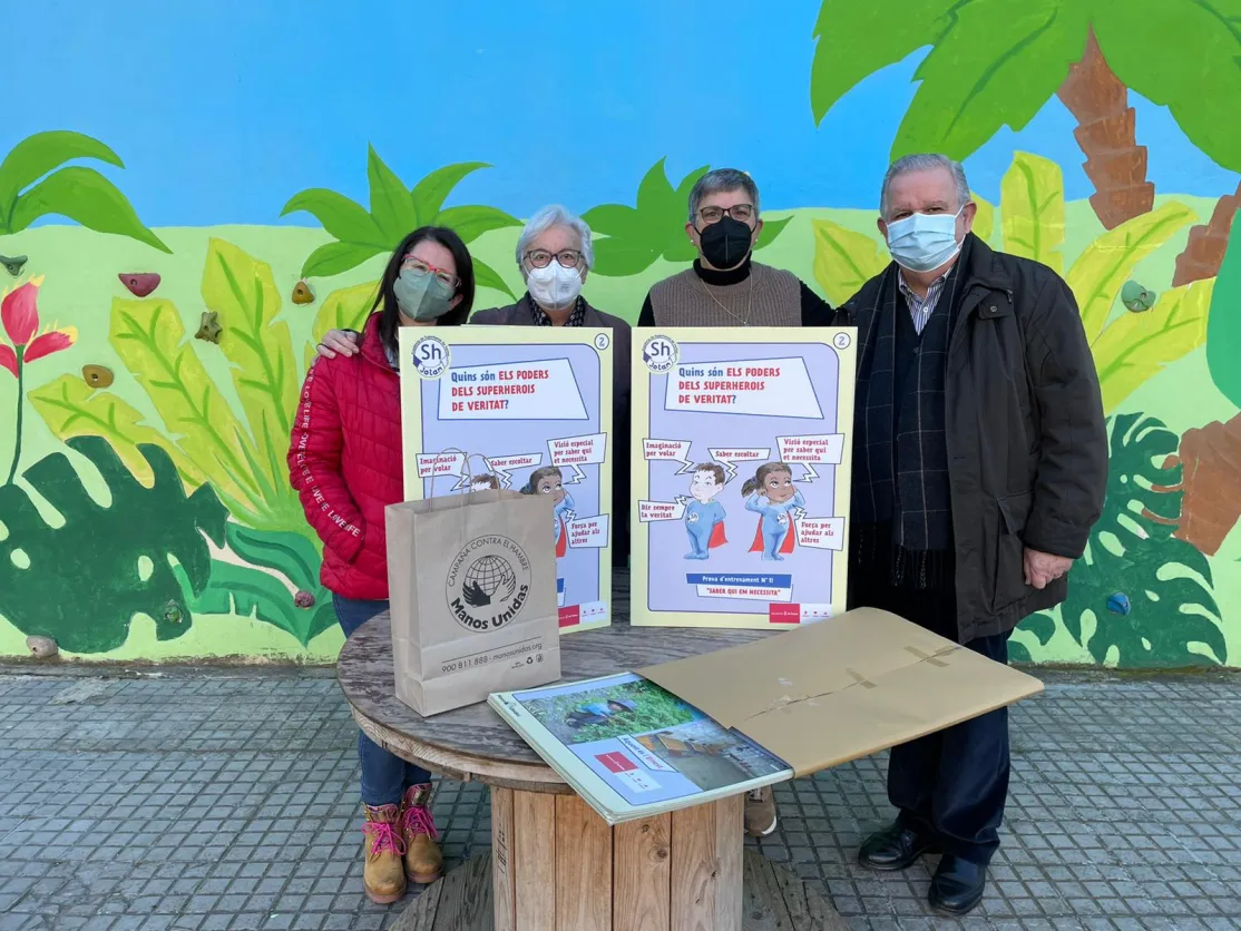 Los voluntarios de Manos Unidas entregan el material educativo al Colegio Corpus Christi