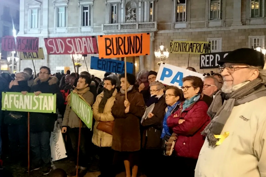 Manifestantes llevan banderas con los nombres de países donde se vive en situación de guerra.
