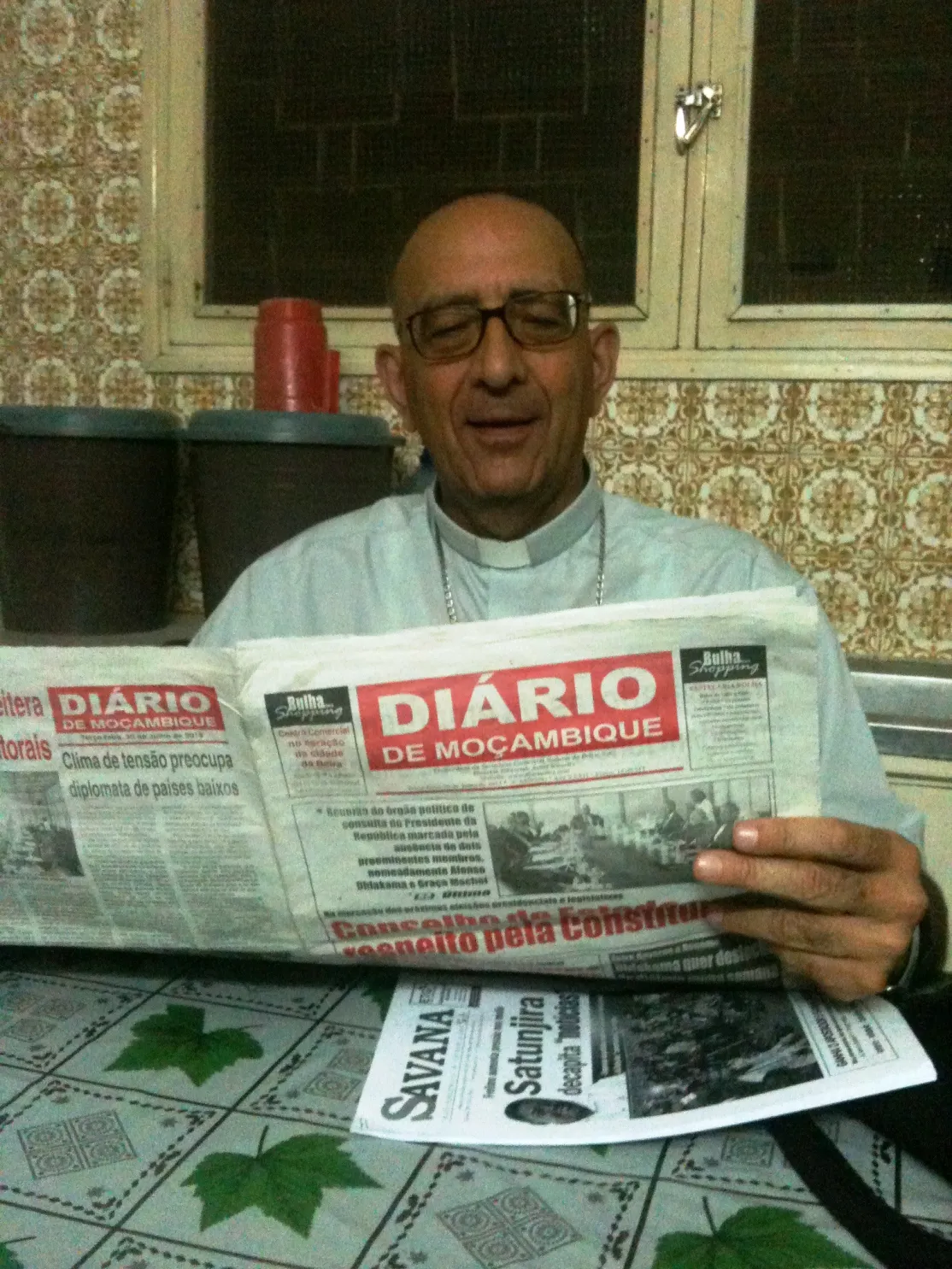 Monseñor Omella lee la prensa en Mozambique. Foto Marta Peláez/Manos Unidas