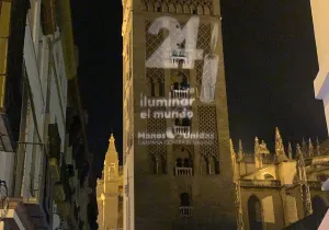 Giralda de Sevilla con el logo de Las 24 Horas de Manos Unidas