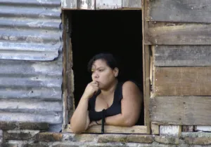 Manos Unidas - En Honduras, los activistas y los jóvenes pobres corren serio peligro - Un joven hondureña mira al horizonte desde su ventana