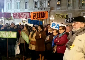 Manifestantes llevan banderas con los nombres de países donde se vive en situación de guerra.