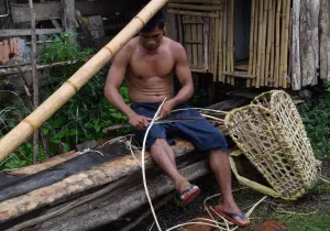 Un pescador de Filipinas elaborando una cesta de pesca.