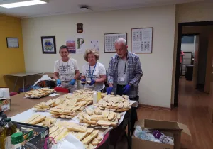 Voluntarios de Manos Unidas preparando el pan con aceite.