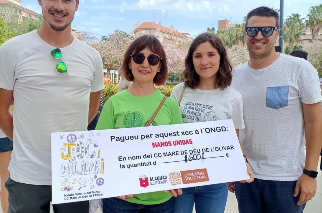 Recogida del cheque de manos de la directora del centro educativo, junto con dos profesores y la representante de Manos Unidas en Alacuás, Clara Sarrió.