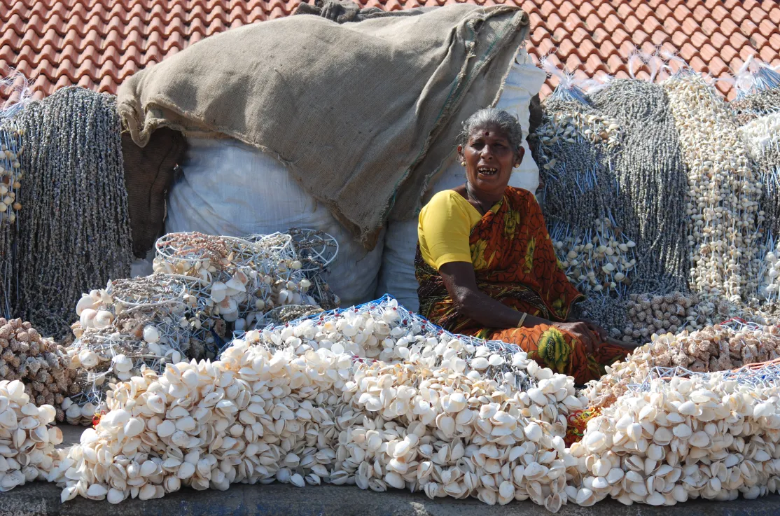 Anciana junto a redes con conchas en Kanyakumari en el estado de Tamil Nadu, en India. Foto: Manos Unidas/Campaña