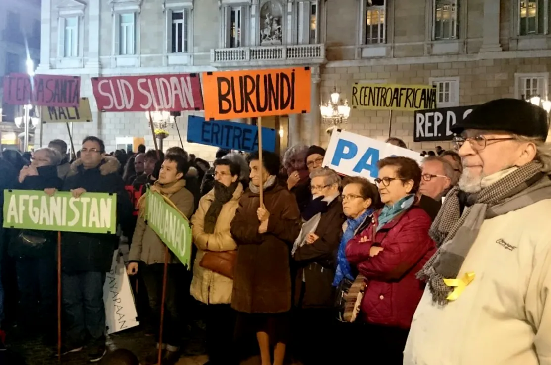Manifestantes llevan banderas con los nombres de países donde se vive en situación de guerra.