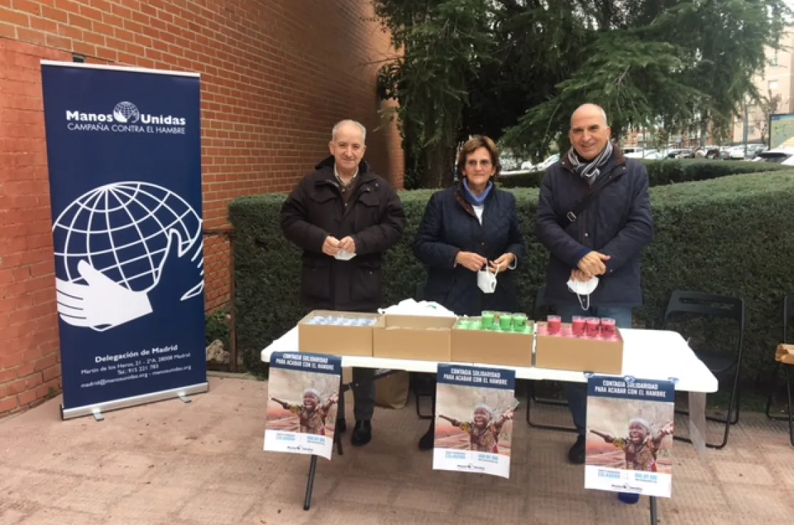 Voluntarios de Manos Unidas vendiendo de velas en la parroquia de San Agustín en  Alcobendas
