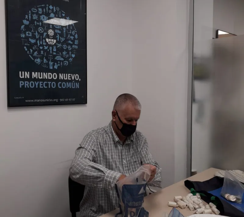 Uno de los voluntarios de Manos Unidas Valencia clasificando monedas y billetes.