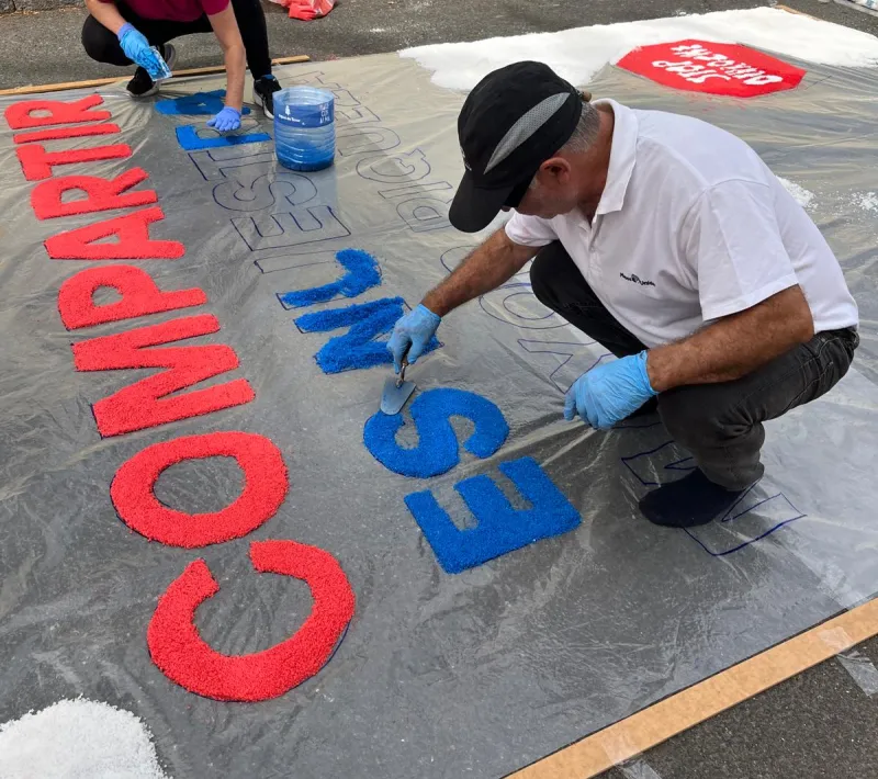 Alfombra de sal con el lema de la campaña "compartir es nuestra mayor riqueza".