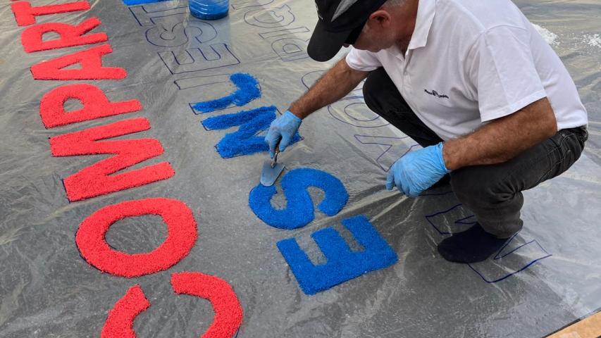 Alfombra de sal con el lema de la campaña "compartir es nuestra mayor riqueza".