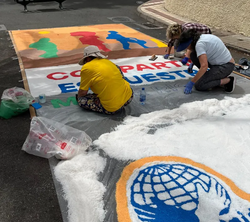 Alfombra de sal con el lema de la campaña "compartir es nuestra mayor riqueza".