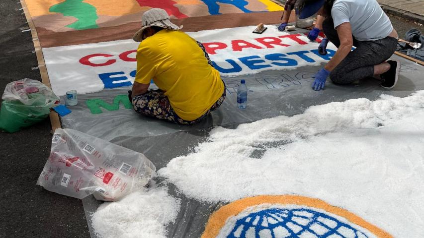 Alfombra de sal con el lema de la campaña "compartir es nuestra mayor riqueza".