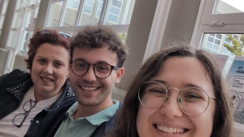 Tres integrantes de Manos Unidas sonríen durante su participación en la Feria de Itinerarios Profesionales de la Facultad de Derecho de Cáceres.