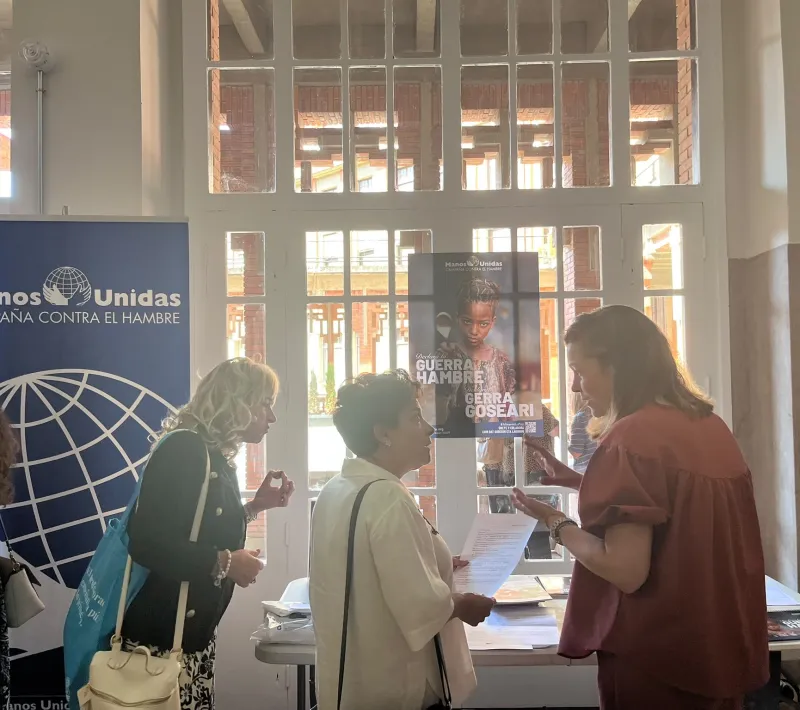 Una voluntaria de Manos Unidas atendiendo a una profesora de religión