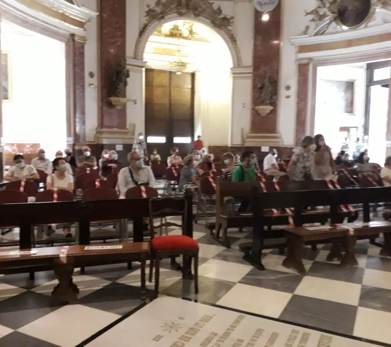 Asistentes a la misa por los fallecidos y afectados por la pandemia en Manos Unidas.