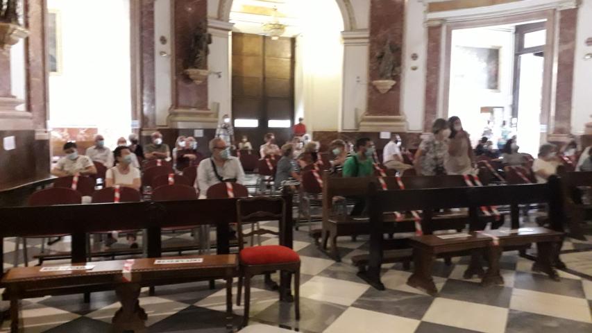 Asistentes a la misa por los fallecidos y afectados por la pandemia en Manos Unidas.