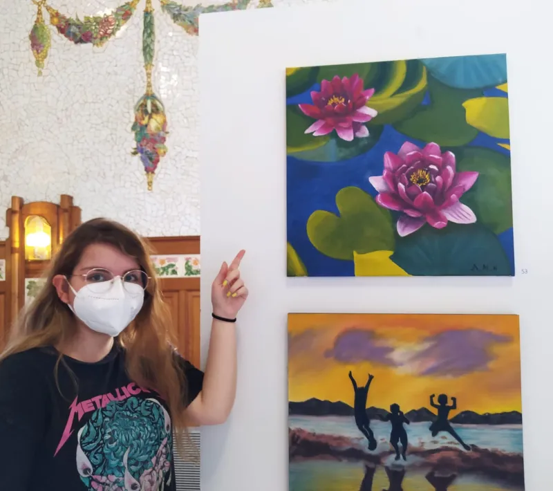 Una de las artistas de la Escuela Gaia junto a su cuadro en la exposición de la Estación del Norte.