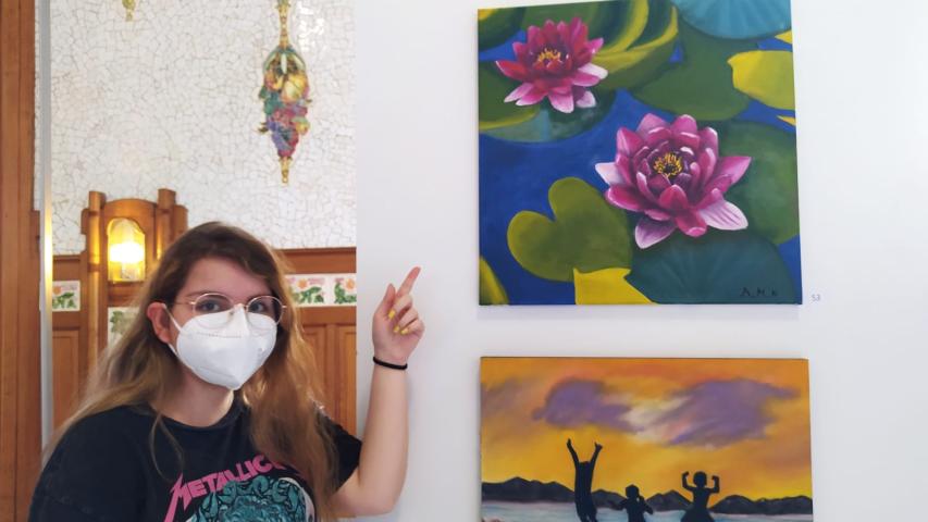 Una de las artistas de la Escuela Gaia junto a su cuadro en la exposición de la Estación del Norte.