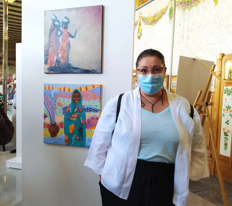 Una pintora de la Escuela Gaia con su obra donada a Manos Unidas Valencia.