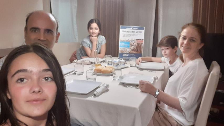 Cena del Hambre Virtual de Manos Unidas Valencia, familia reunida para la cena solidaria.