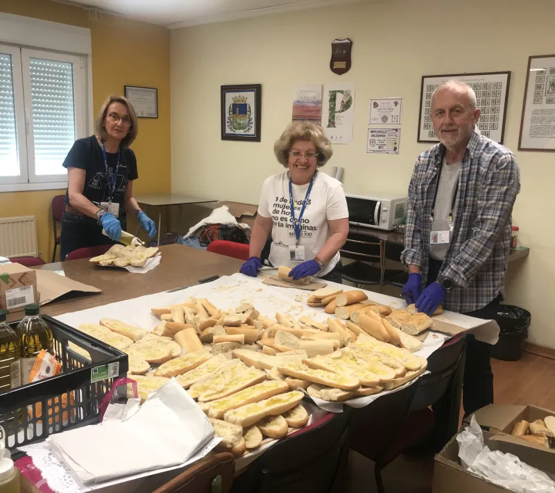 Voluntarios de Manos Unidas preparando el pan con aceite.