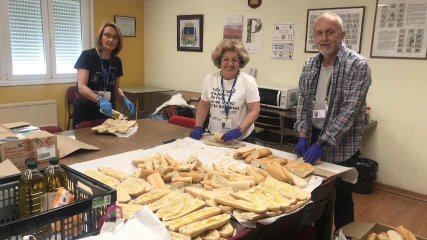 Voluntarios de Manos Unidas preparando el pan con aceite.