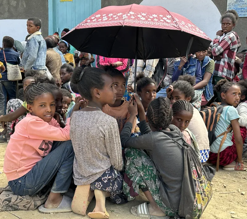 Un grupo de estudiantes se protege del sol a las puestas de la escuela en Tigray (Etiopía). Foto: Manos Unidas/Marta Carreño