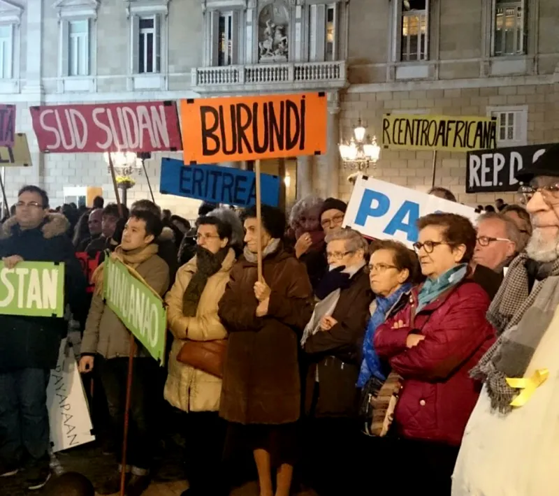 Manifestantes llevan banderas con los nombres de países donde se vive en situación de guerra.