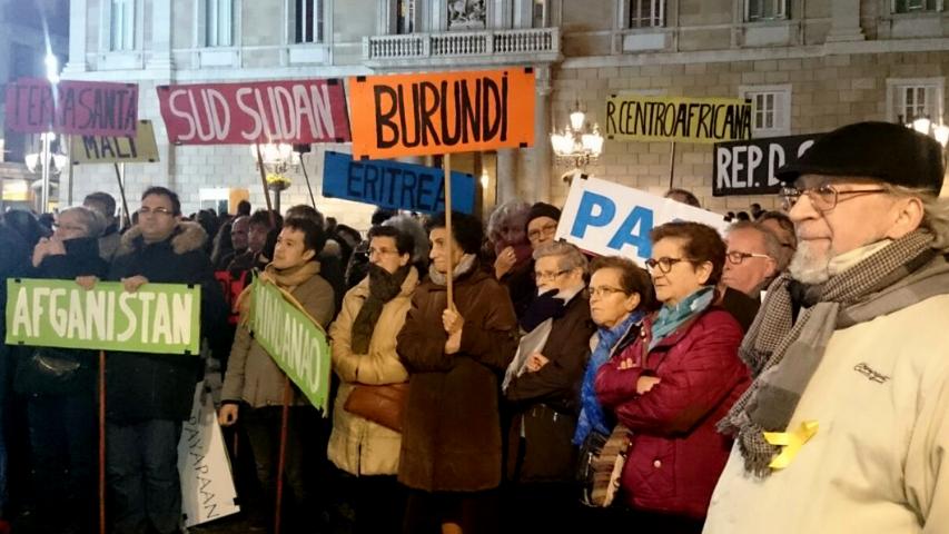Manifestantes llevan banderas con los nombres de países donde se vive en situación de guerra.