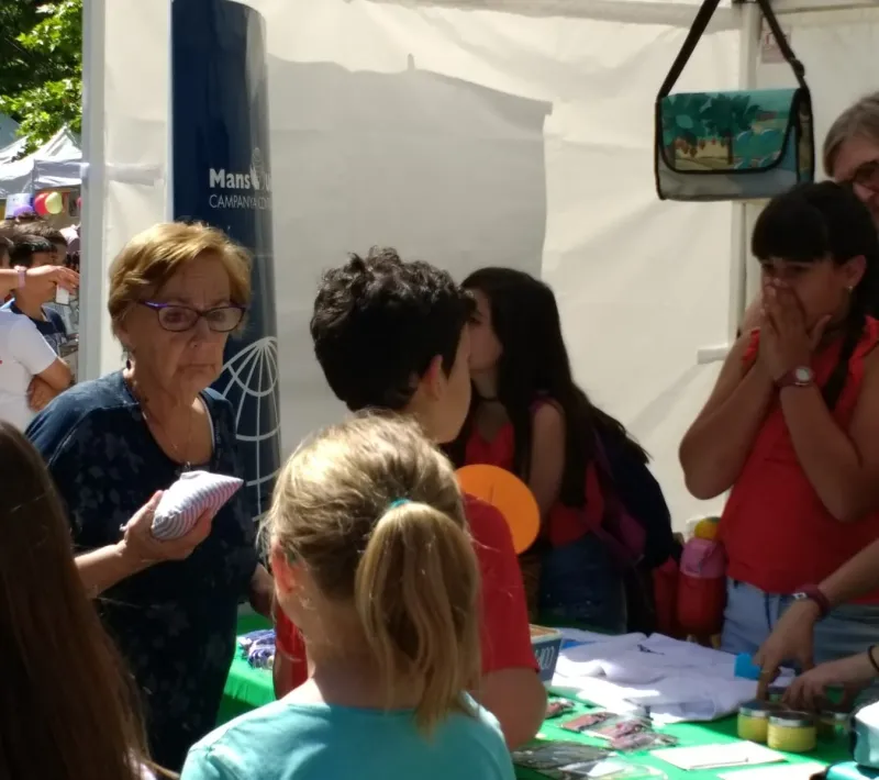 Stand de Manos Unidas con alumnos, en el mercado cooperativo