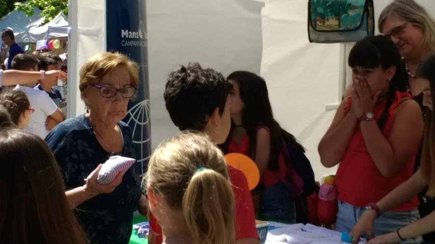 Stand de Manos Unidas con alumnos, en el mercado cooperativo