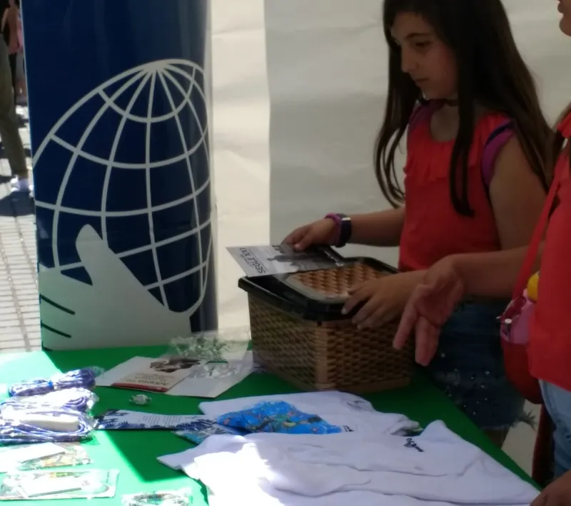 Stand de Manos Unidas con alumnos, en el mercado cooperativo