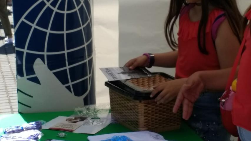 Stand de Manos Unidas con alumnos, en el mercado cooperativo