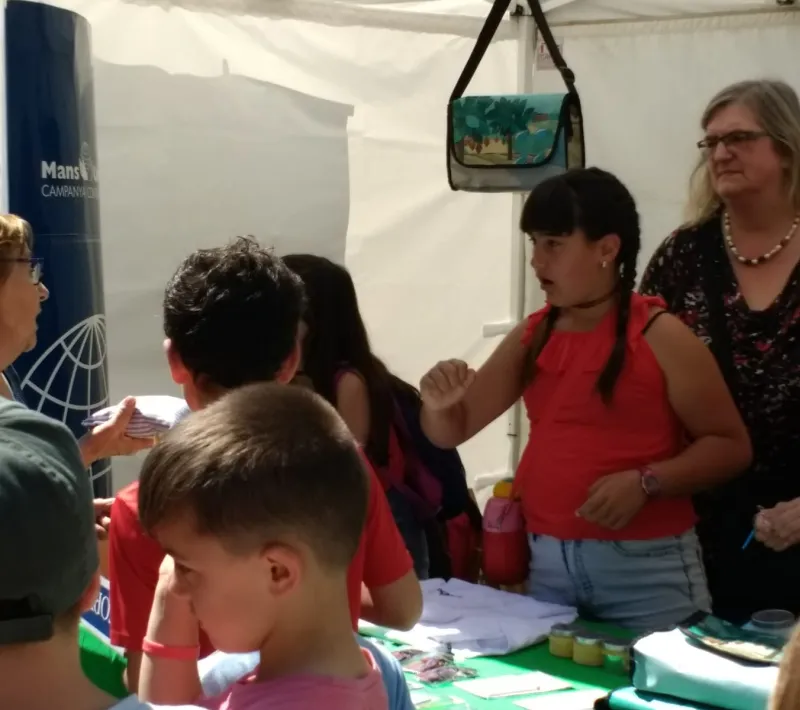 Stand de Manos Unidas con alumnos, en el mercado cooperativo