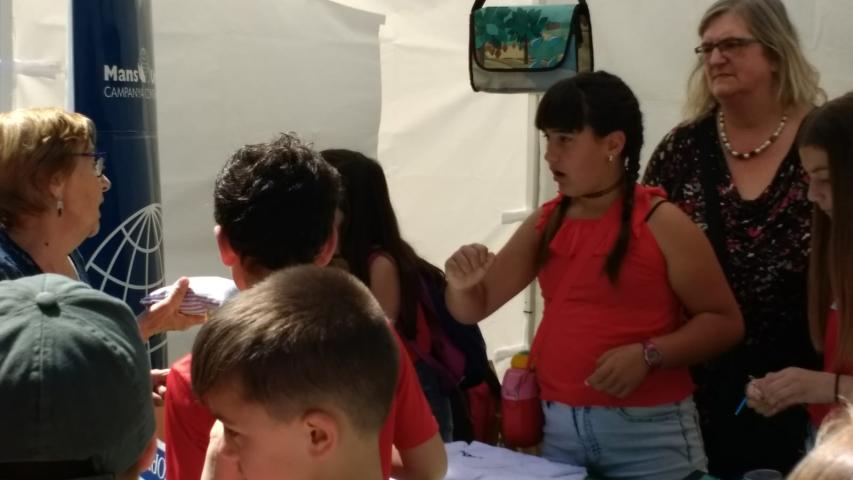 Stand de Manos Unidas con alumnos, en el mercado cooperativo
