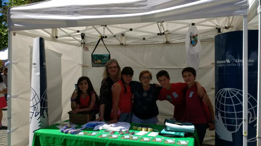 Stand de Manos Unidas con alumnos, en el mercado cooperativo