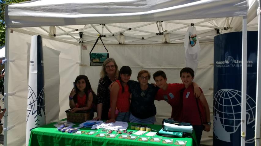 Stand de Manos Unidas con alumnos, en el mercado cooperativo