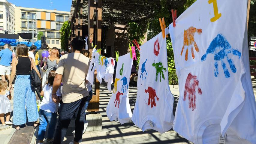 Secado de las camisetas estampadas con las manos de los niños pintadas.