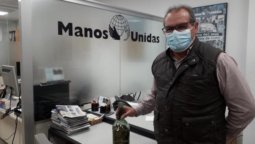 Donación de una botella llena de monedas que recogió una niña en su Primera Comunión hace más de 30 años. Manos Unidas Valencia.