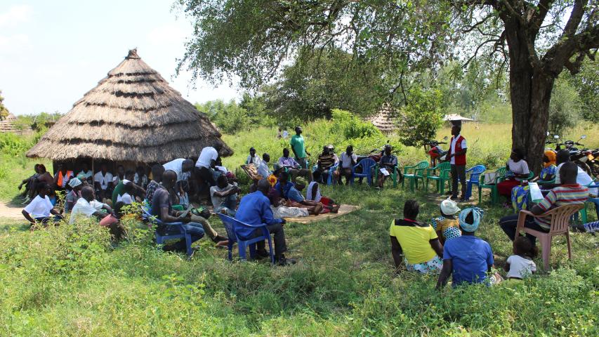 project officer in red briefing the community members during group foirmation