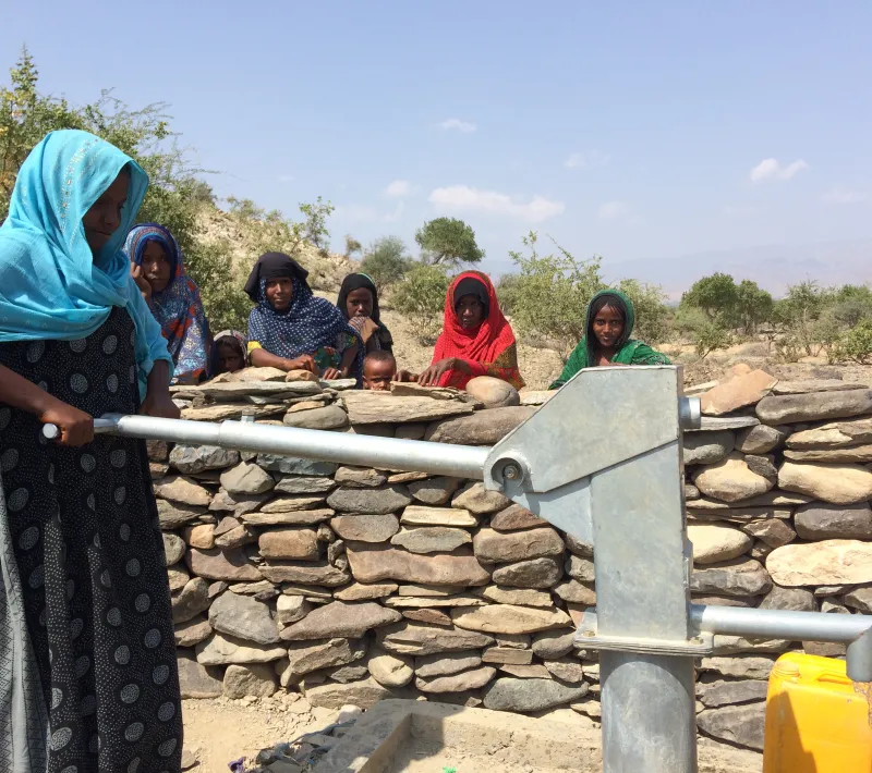 Una mujer extrae agua de una fuente en Afar, Etiopía - Foto Manos Unidas