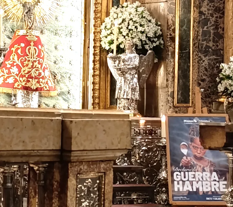 Cartel de la Campaña "Declara la guerra al hambre" a los pies de la Virgen del Pilar